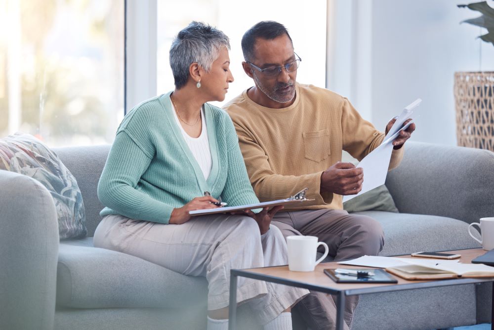 Senior couple reviewing documents siting on a sofa
