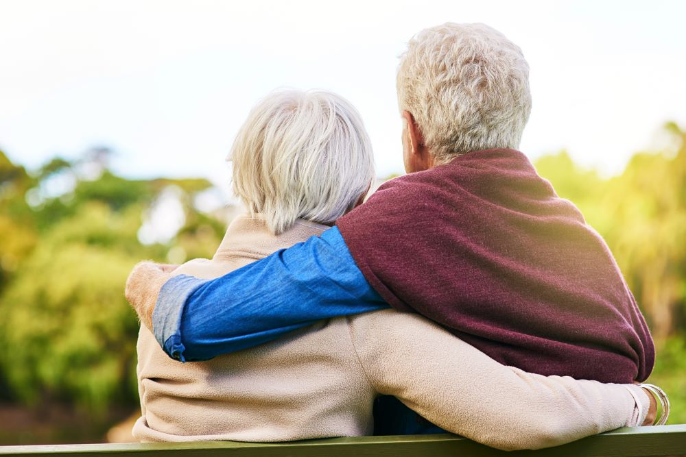Photo from the back of a senior couple sitting on a bench